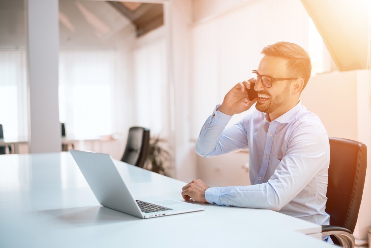 Man at desk on phone working on How to Make Your Outbound Lead Generation Succeed