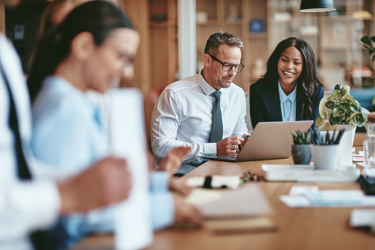 People sitting at office desk discussing a New Way to Leverage Image SEO for Traffic